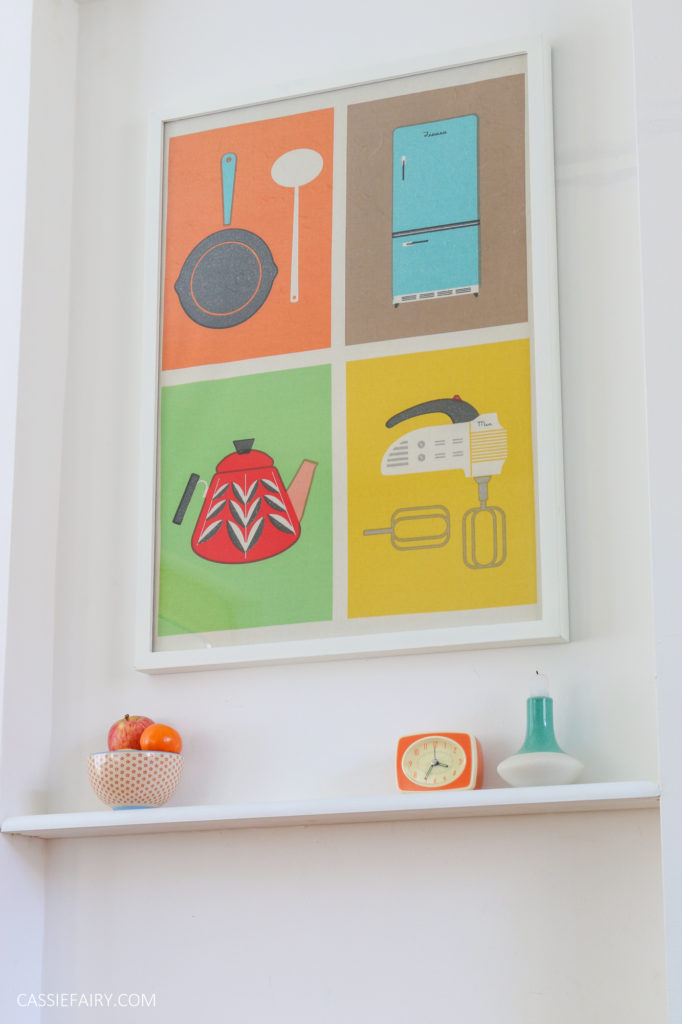 photo of a colourful poster framed and hung in a kitchen 