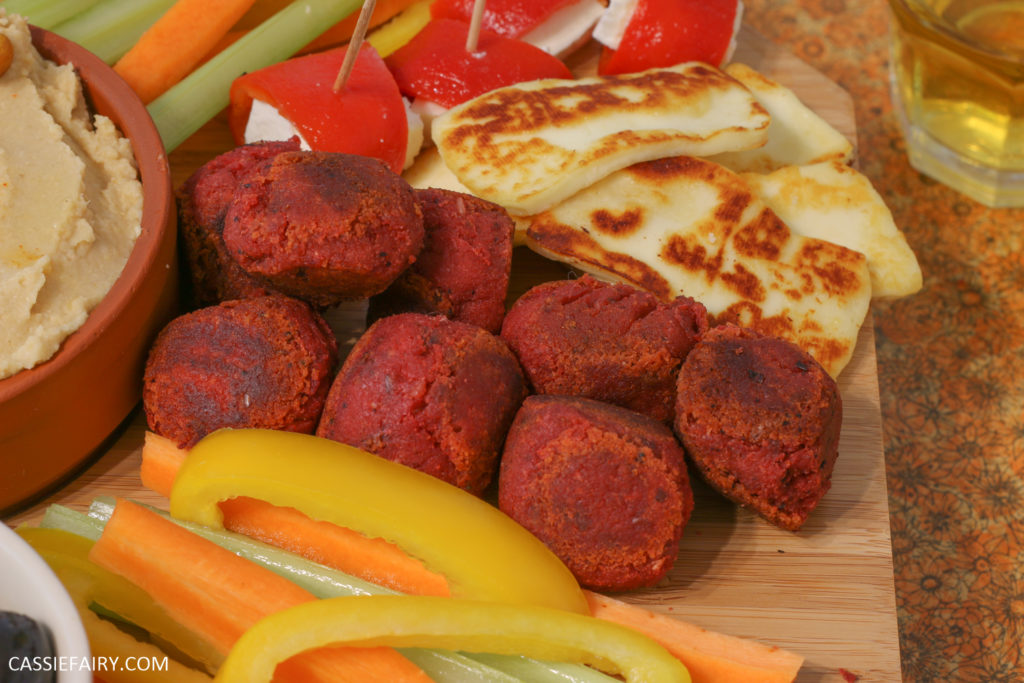 A platter of vegetables, haloumi, and chickpea falafel balls.