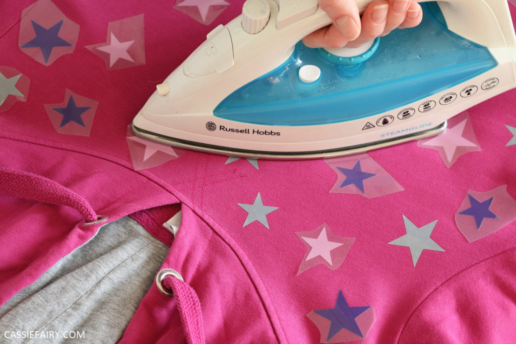 Photo of heat-transfer vinyl stars being applied to a hoody 