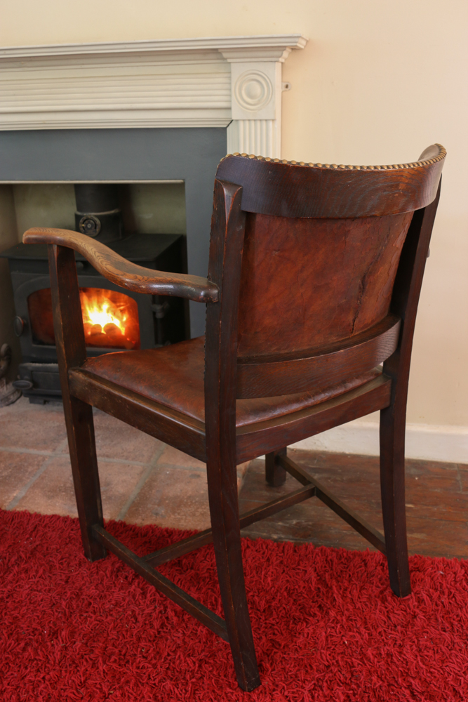 The repaired back of the leather chair with only a tiny dark edge to the split indicating where the tear once was.